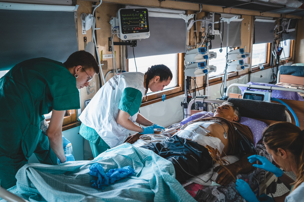 Het medische team in de intensive care unit (ICU) van de medische trein van AzG bewaakt en stabiliseert een ernstig door de oorlog gewonde patiënt tijdens de reis van Pokrovsk, Oost-Oekraïne naar Lviv, in West-Oekraïne. De reis duurt ongeveer 20 uur. Sinds 31 maart hebben we meer dan 600 patiënten vervoerd.