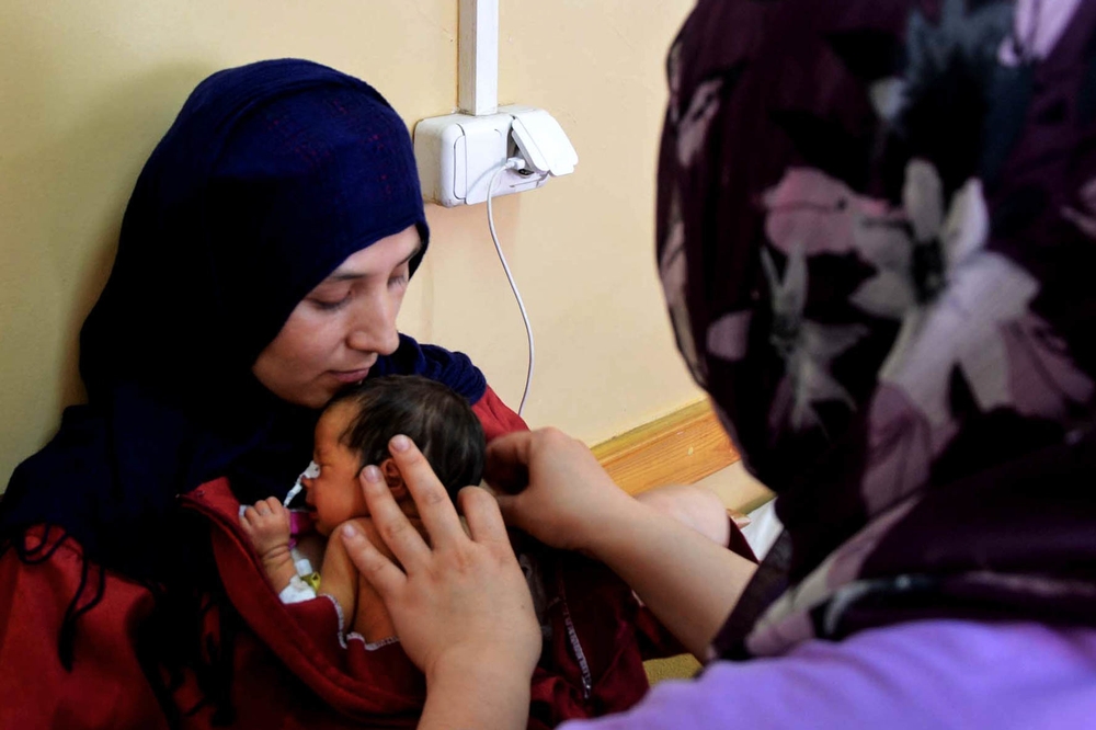 une jeune mère afghane apprend la technique de peau-à-peau dans l'unité de soins de Dasht-e-Barchi en Afghanistan