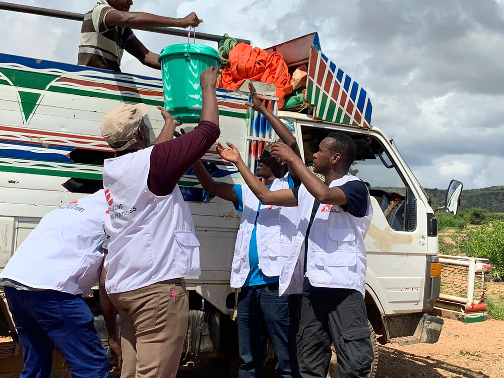 Le personnel MSF porte des seaux