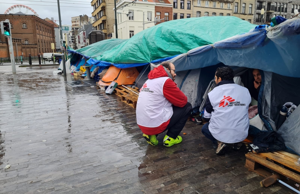 L'équipe MSF s'agenouille devant le camp de tentes à Bruxelles