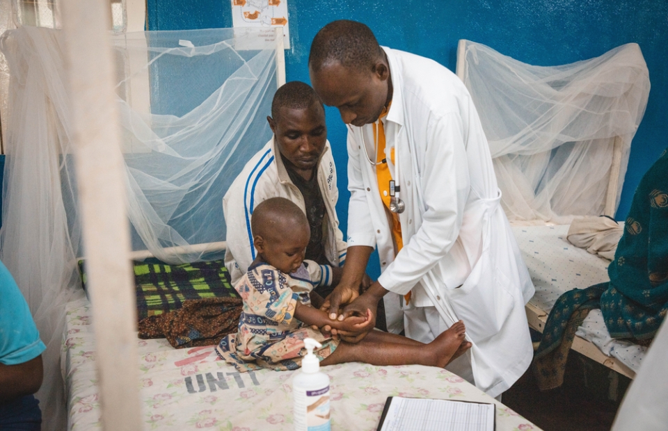 Lors de la visite médicale matinale, un médecin examine les œdèmes sur le corps d’Alice, une patiente admise pour malnutrition aiguë sévère au Centre de récupération nutritionnelle intensive de l’hôpital général de référence de Masisi
