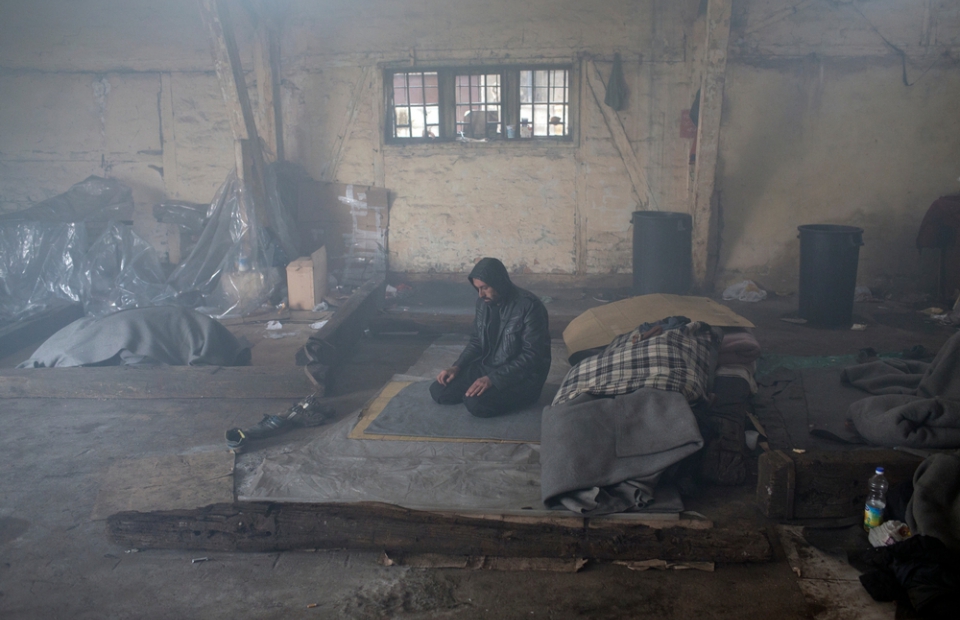 Un homme prie au sein d'un entrepôt à Belgrade. © Marko Drobnjakovic. Serbie, 2016. 