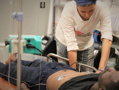 Dr. Stefanie prend le pouls d'un patient à bord de l'Ocean Viking © Hannah Wallace Browman/MSF. 16 août 2019.