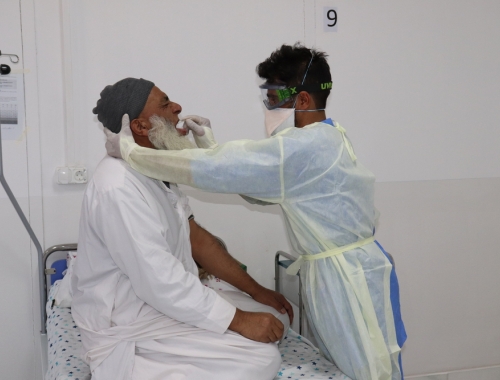 Norrulah Nasrat, infirmier MSF, prélève un échantillon sur Mohammadin, un patient suspecté d'être atteint du COVID-19, dans le centre de traitement du COVID-19 de MSF à Herat, en Afghanistan. © Waseem Muhammadi