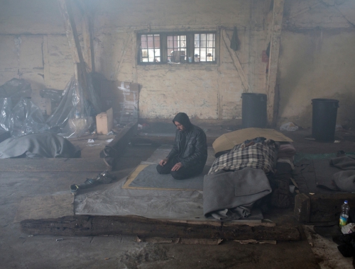 Un homme prie au sein d'un entrepôt à Belgrade. © Marko Drobnjakovic. Serbie, 2016. 