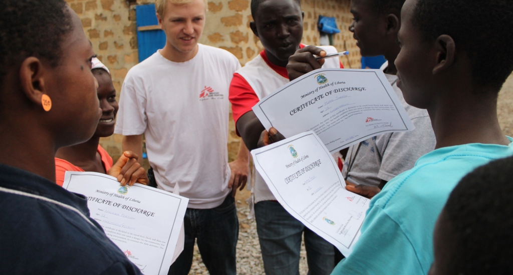 © Martin Zinggl/MSF - Jesse et Djaminah, HP local, distribuent des certificats de décharge aux 6 survivants d’Ebola confirmant qu’ils sont guéris. Djaminah plaisante avec eux et essaie de leur faire comprendre de quelle terrible maladie ils viennent de se remettre.