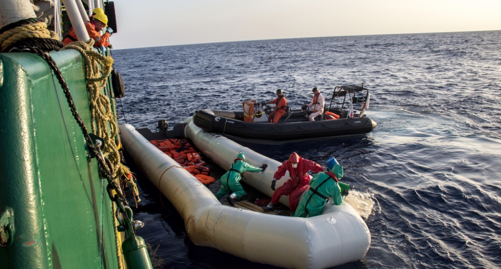 Als alle vluchtelingen aan boord van het schip zijn, worden de lijken geborgen. Er worden beschermende pakken en maskers gedragen ter bescherming tegen de brandwonden en giftige dampen die de mix van zeewater en brandstof kunnen doen ontstaan. © Borja Ruiz Rodriguez/AZG